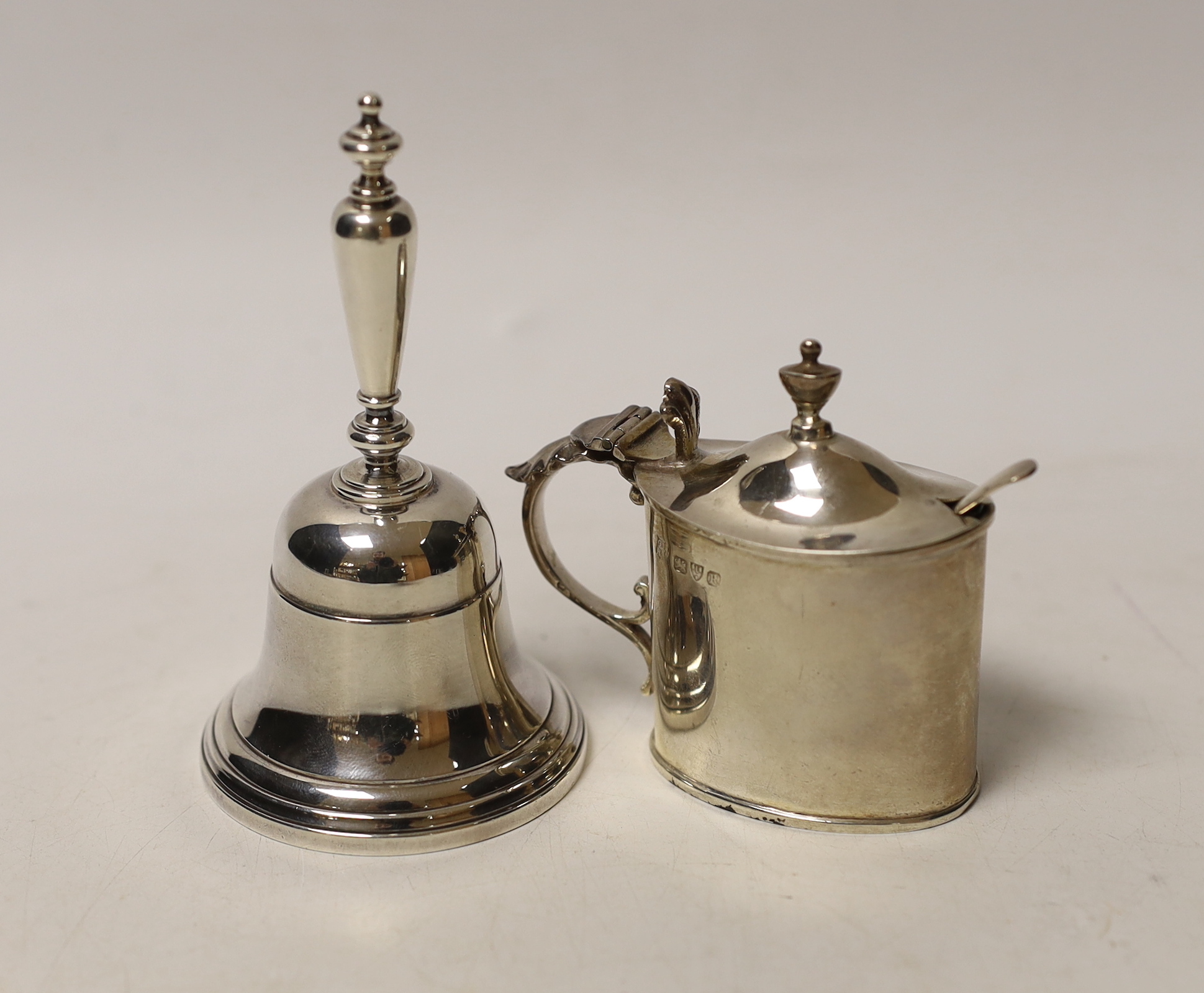 A modern silver hand bell, 10.5cm and a late Victorian silver mustard pot, Chester, 1900 and a spoon.